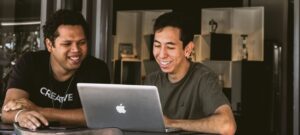 dwóch mężczyzn przed laptopem